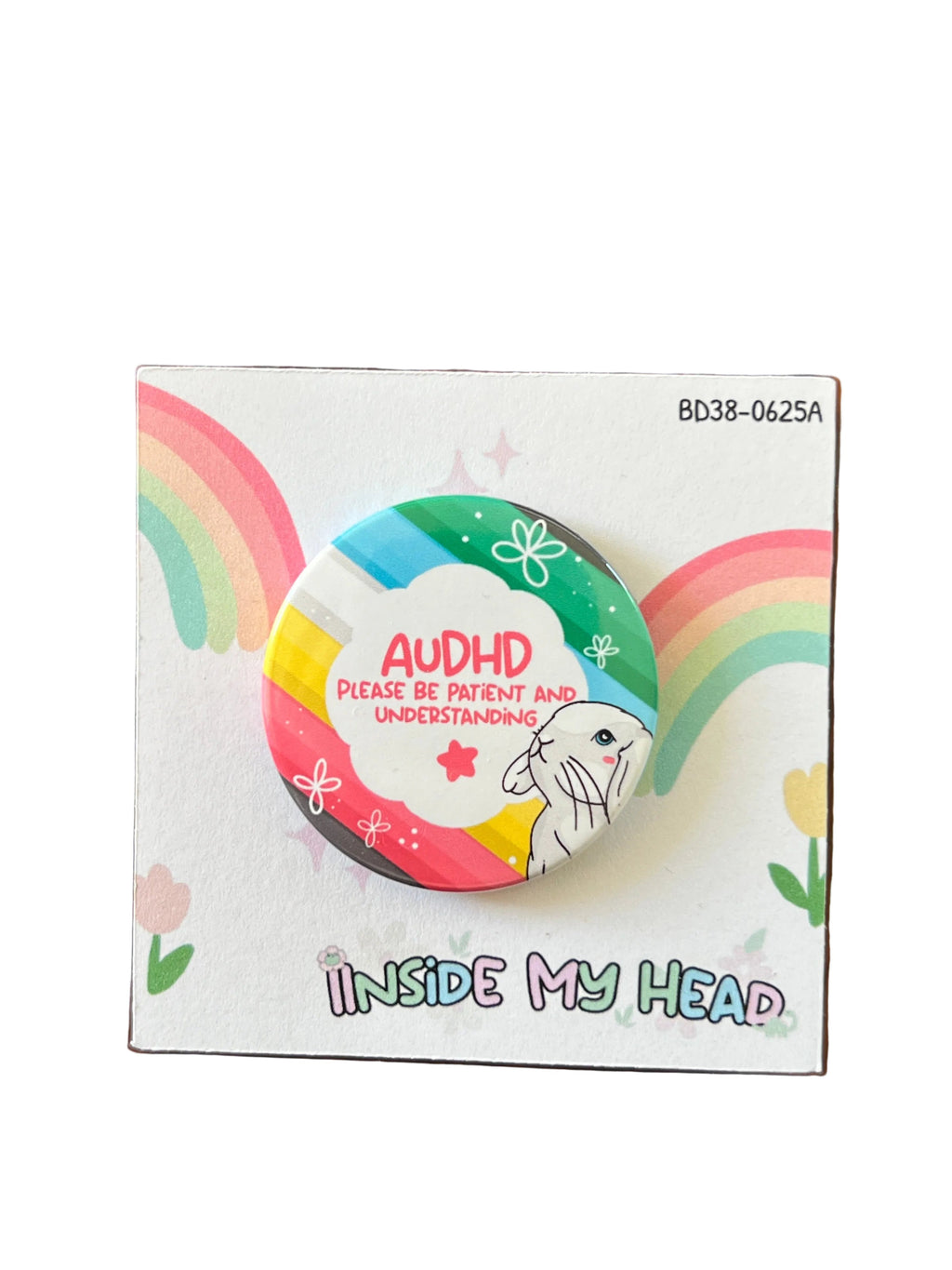 A round pin badge featuring a colorful rainbow design, a white rabbit, and the text 'AUDHD PLEASE BE PATIENT AND UNDERSTANDING', displayed on its printed backing card which reads 'INSIDE MY HEAD' and is photographed on a wooden tabletop.