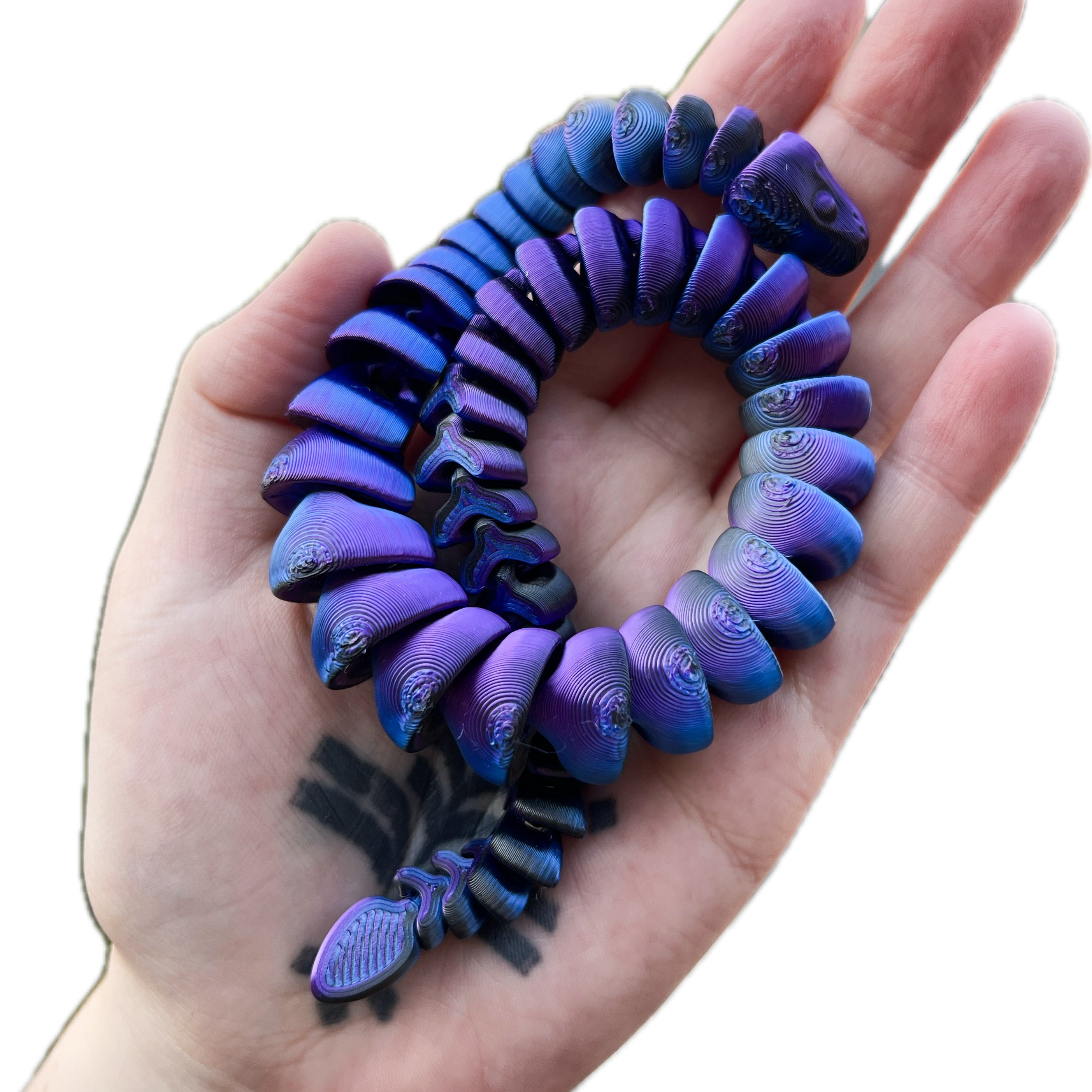 Purple and blue snake fidget on a hand against a white background